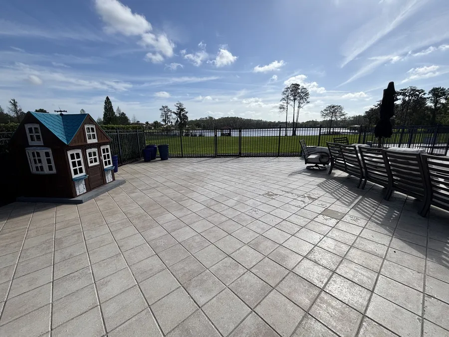 Wide patio with a childrens playhouse and a lake view